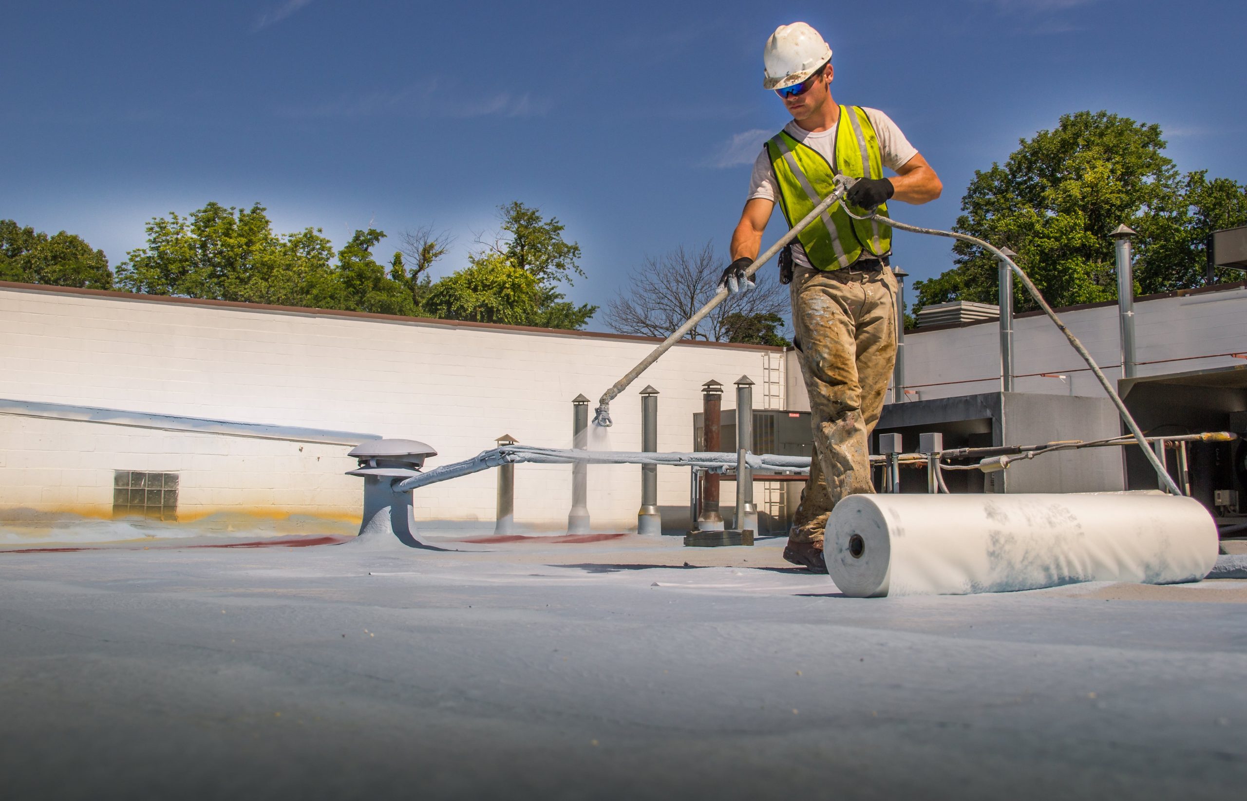 A man applying a protective coating to a roof.